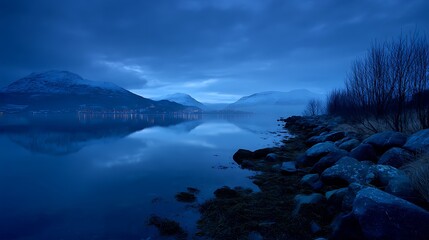 Serene blue hour landscape with calm water and mountain reflections