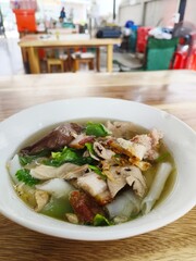 Kuay jap, a Thai-Vietnamese style fast food dish. Noodles are made from rice flour and topped with pork soup, pork and offal, and topped with crispy pork. It's delicious.