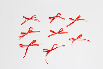 Multiple red ribbon bows arranged in a creative pattern on a white background