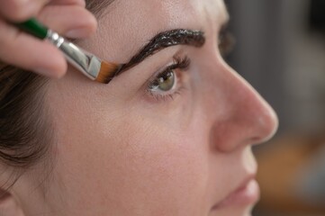 Caucasian woman getting eyebrow tinting procedure. 