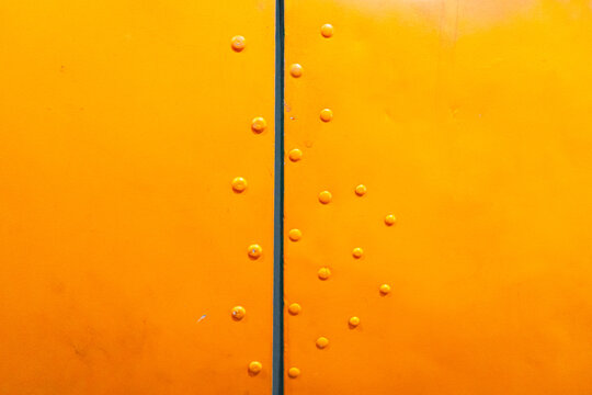 Close-up of riveted yellow aircraft fuselage with visible screws and gap - Powered by Adobe