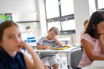 Tired schoolboy struggling to stay awake during class