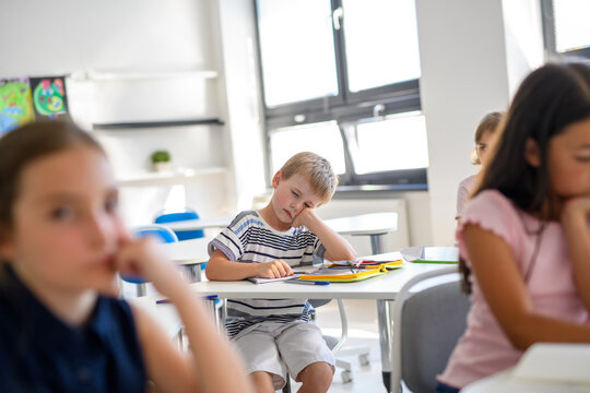 Tired schoolboy struggling to stay awake during class