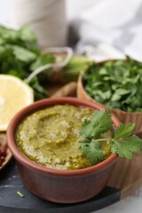 Tasty sauce with cilantro and other ingredients on table, closeup