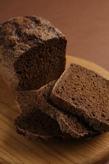 Pieces of fresh rye bread on brown background, closeup