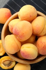 Fresh ripe apricots in bowl on table, flat lay