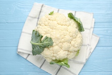 Whole cauliflower on light blue wooden table, top view
