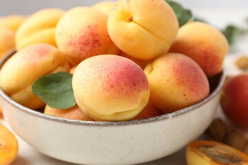 Fresh ripe apricots in bowl on table, closeup