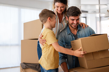 Smiling man and woman enjoy unpacking with child moving to own home. Rent, mortgage concept