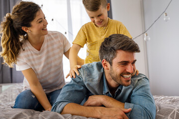 Obraz premium Happy family leisure. Cheerful mother, father and son having fun together on weekend at home