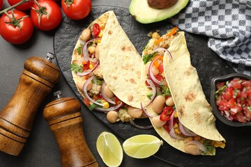 Tasty vegetarian tacos with beans and quinoa served on grey table, flat lay