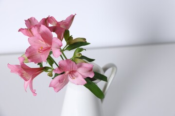Beautiful flowers in vase on white table, closeup. Space for text
