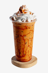 Iced Thai milk tea with whipped cream on wooden coaster