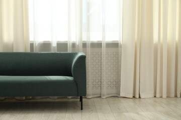 Stylish furniture near window with curtains in living room. Interior design