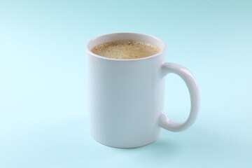 Aromatic coffee in cup on light turquoise background, closeup. Mockup for design