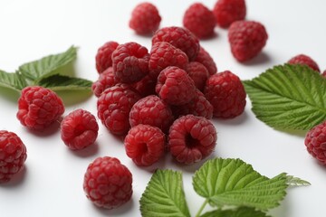 Tasty fresh ripe raspberries and leaves on white background, closeup