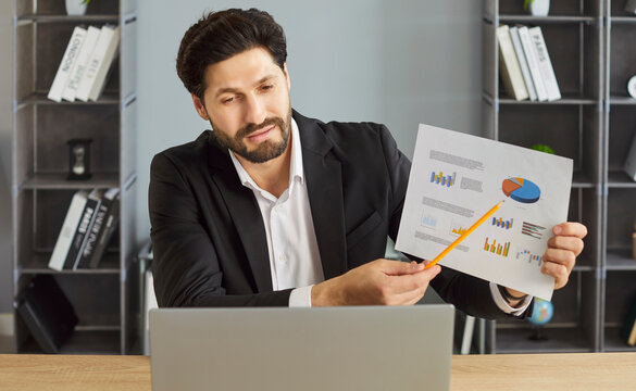 Data analysis presentation of confident businessman during video call to partner in office. Busy man sitting at desk to present financial chart of sales or project profits. Accounting concept - Powered by Adobe