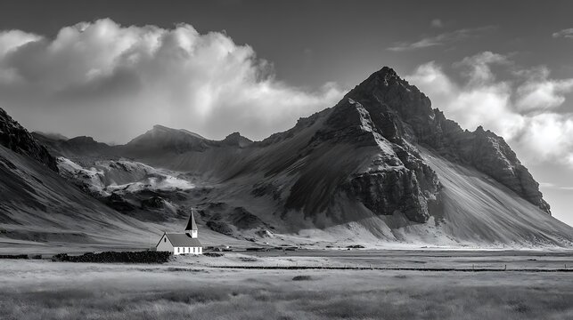 Dramatic black and white mountain landscape with a solitary church