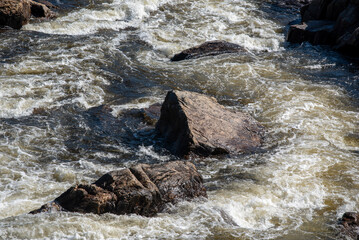 streams of clear waterfall water and stone banks of a mountain river