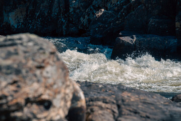 streams of clear waterfall water and stone banks of a mountain river