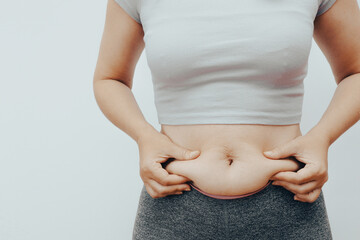 Closeup hand holding abdominal surface woman fat, healthy care and beauty concept. Healthcare and woman diet lifestyle concept