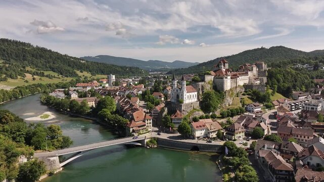 Aare river winding through Aarburg, Switzerland, drone aerial view, sunset glow over historic townscape.