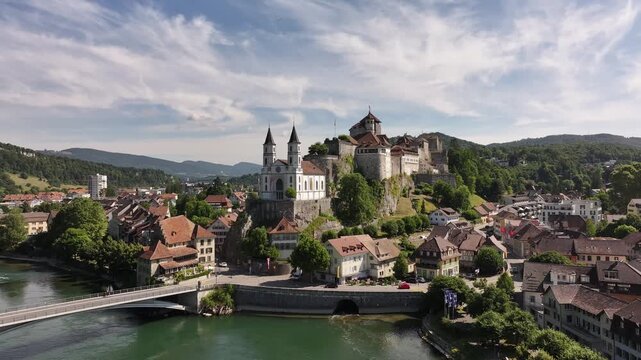 Aarburg castle and church on rocky hill beside Aare river in Switzerland, stunning drone aerial view.