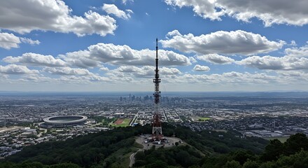 Cityscape with Tower and Stadium Under Cloudy Sky