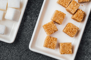 Brown sugar cubes and white sugar cubes arranged on plates