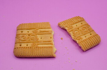 Indulge your sweet tooth with this delicious broken biscuit on a vibrant pink background tempting treats and delightful snacks