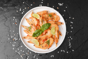 Shrimp with herbs and coarse salt on black surface for cooking background or seafood concept