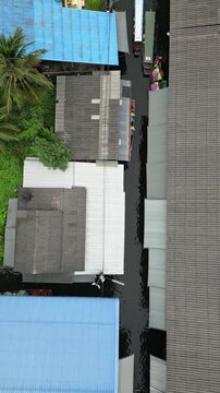Aerial view of buildings with colorful rooftops and lush greenery on Dinso Road, a vibrant urban scene with contrasting textures, Khet Phra Nakhon, Krung Thep Maha Nakhon, Thailand.