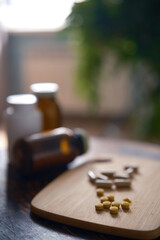 home interior different types of food supplements and tablets for health and wellness. Vegan capsules and tablets, green plant leaves background
