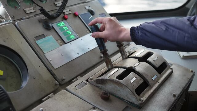 Captain operating levers on ship's bridge control panel. Clip