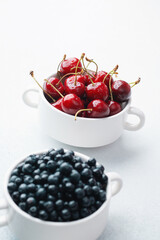 Bowls of raspberries, blueberries and cherries for fruit trio, diet or nutrition concept