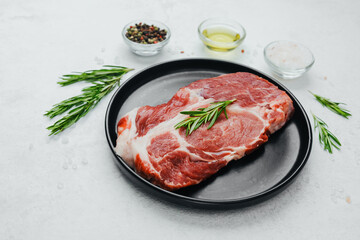Pork steak with rosemary on black plate with spices