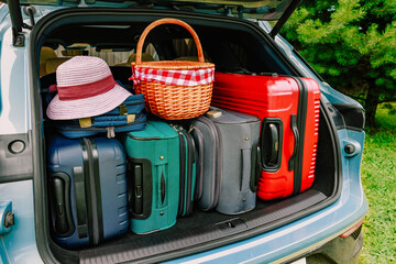 Car trunk is full of luggage. Open trunk of hybrid electric car with modern suitcases, ready for travel.