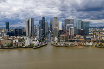 Obraz premium Wide drone view showing the skyline of Canary Wharf aligned with the dock entrance.