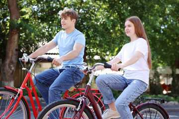Obraz premium Teenage girl and boy riding bicycles on city street