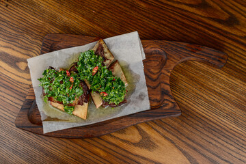 Braised pork ribs with herbs on a wooden board on a wooden background