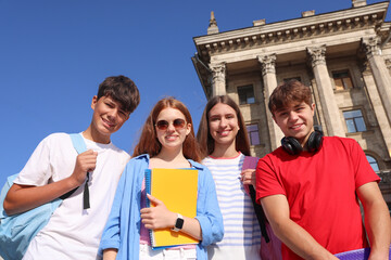 Group of teenagers walking together on city street, low angle view