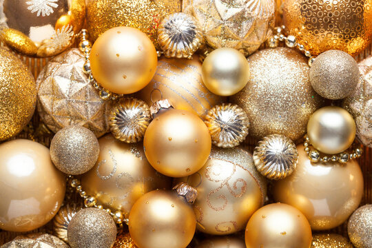 Christmas Holiday background with shiny golden balls.Close up of pile golden Christmas decorations different sizes, shades and textures.  Flat lay
