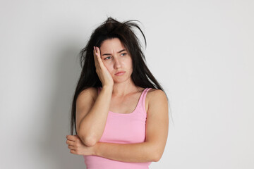 Woman suffering from hangover on light grey background