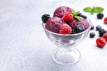 Delicious sorbet with fresh berries and mint in dessert bowl on grey textured table, closeup. Space for text