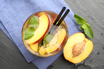 Refreshing iced peach tea in glass on grey table, flat lay