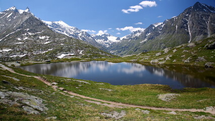 Reflections on lac Perrin superieur (Perrin upper lake) located above Petit Mont Cenis Pass (near Mont Cenis lake), Maurienne Valley, Savoie, Northern French Alps, France, surrounded by mountains