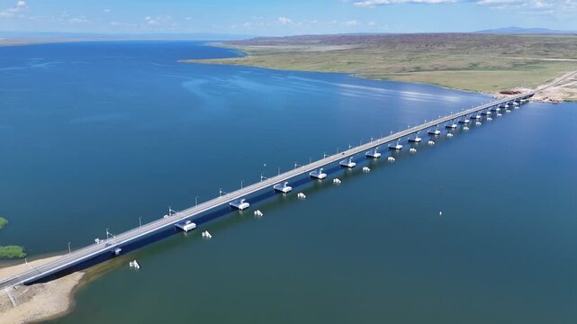 Aerial flyover from left to right of Kazakhstan's longest bridge across Bukhtarma Reservoir on a sunny summer day in East Kazakhstan Region, 4K, 30fps
