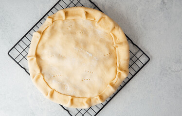 Homemade pie crust  on a cooling rack before baking