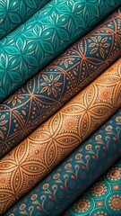 Closeup view of rolled fabrics with intricate teal and orange floral and geometric patterns, showcasing rich texture