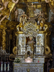 Ornate baroque altar with saint statue inside historic cathedral